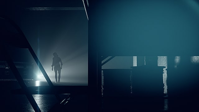 La silhouette de Jess Faden marchant vers une lumière dans un entrepôt sombre.