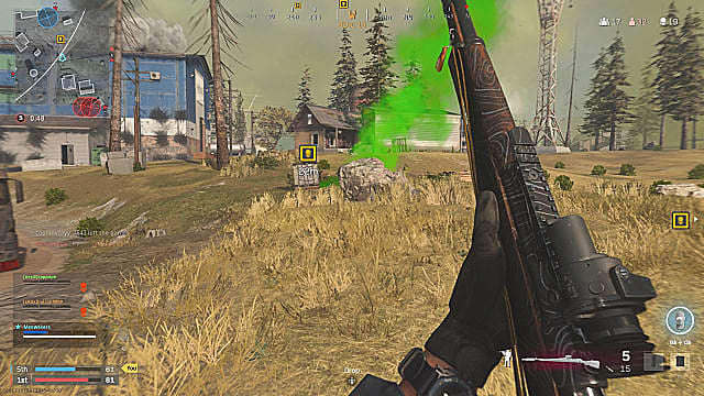 Un joueur tenant un fusil de tireur d'élite, regardant la fumée verte d'une caisse de crâne sur le bord d'une colline herbeuse.