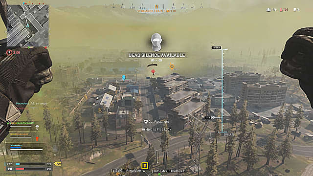 Un joueur parachute sur la carte au-dessus d'un bosquet d'arbres et de bâtiments, marquant d'autres joueurs.