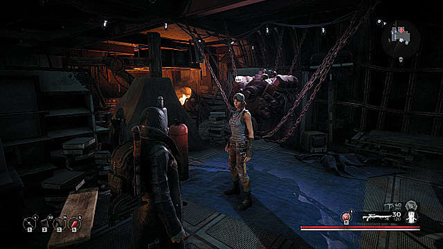 Un joueur masqué regardant McGabe, une femme en débardeur, chapeau et pantalon long dans un atelier d'usinage.