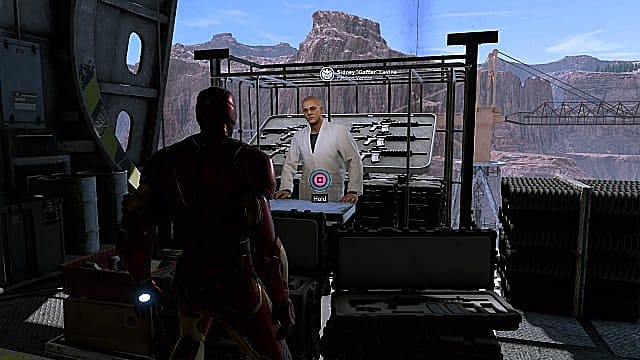 Iron Man debout devant la boutique de Sidney Levine dans le hangar de l'héliporteur. 