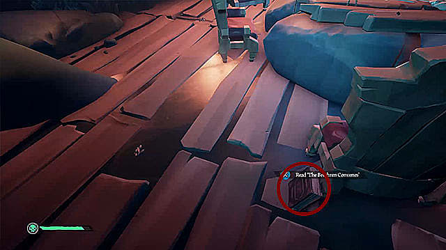 Un journal rouge appuyé contre un pied de chaise en bois sur un bateau pirate.