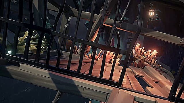 Une cellule de prison de bateau pirate avec des barres pliées et une lanterne suspendue à l'intérieur.