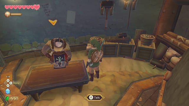 Gondo répare son robot, Scrapper, sur un établi alors que Link se tient à côté.