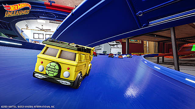 Une camionnette jaune avec une plaque de vanité Teenage Mutant Ninja Turtles en course sur une piste bleue.