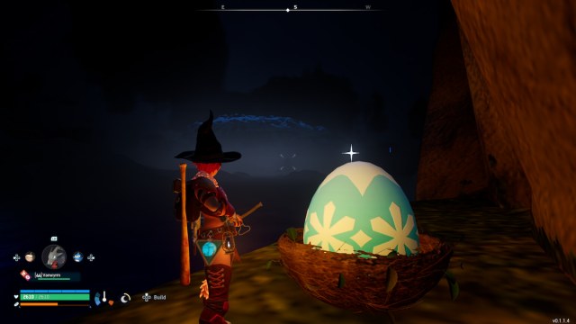 Un joueur debout à côté d’un énorme œuf congelé bleu et blanc la nuit.