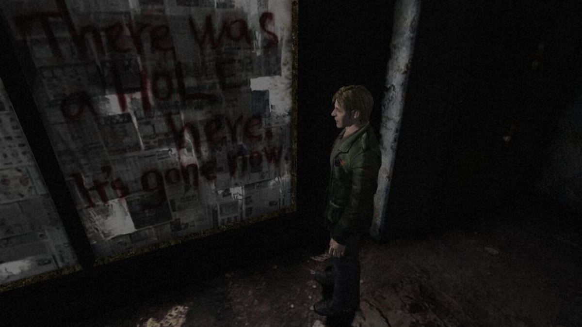 Image promotionnelle pour Silent Hill 2 ;  montrant James à côté d'une écriture sanglante sur un mur.