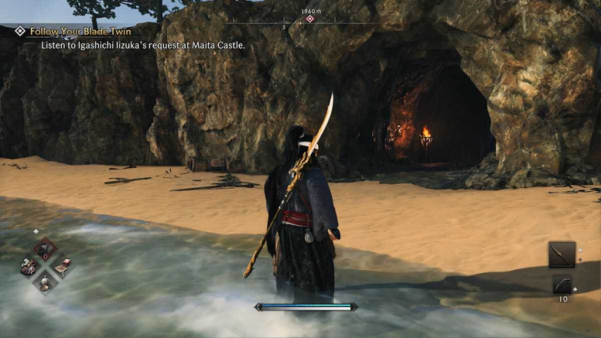 Un guerrier Veiled Edge debout devant une grotte sur la plage dans Rise of the Ronin