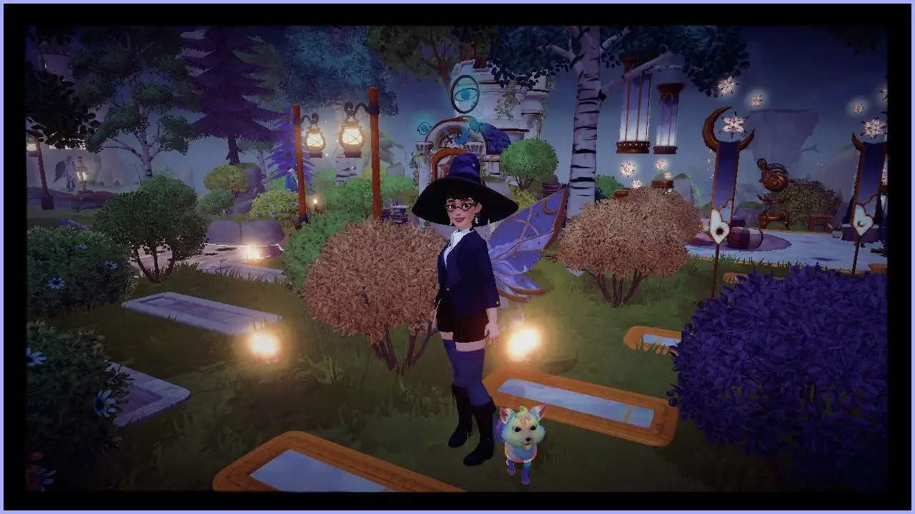 Un avatar féminin de Disney Dreamlight Valley, vêtu d'un chapeau de sorcière avec des ailes bleues et dorées, se tient parmi des buissons jaunes avec un renard arc-en-ciel hargneux.  Au fond, la maison de Merlin est couverte d'arbres.  Des bougies sont éparpillées près d’un chemin bordé d’or.