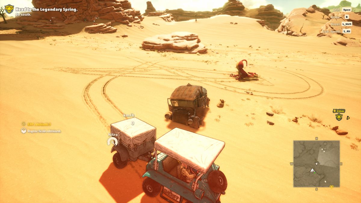 Le véhicule de Rao près d'un rapace rouge mort couché face contre terre dans le sable, l'arrière en l'air.