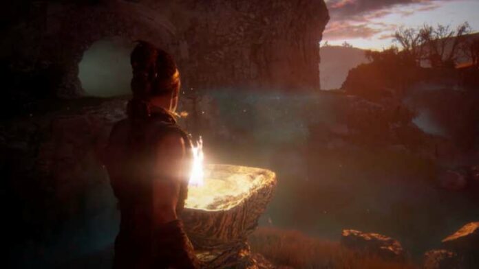 Outdoor brazier puzzle area with glowing cave on a hill in Senua's Saga: Hellblade 2
