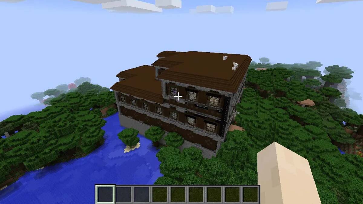 Grand manoir boisé au bord d'une rivière dans Minecraft
