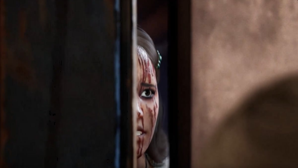 Maria Flores jetant un coup d'œil derrière une porte lors du match Texas Chain Saw Massacre.