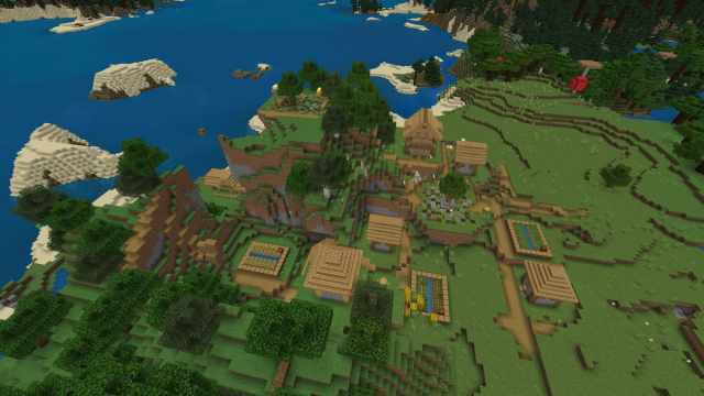 Un village Minecraft avec des bâtiments au sommet et en dessous d'une colline