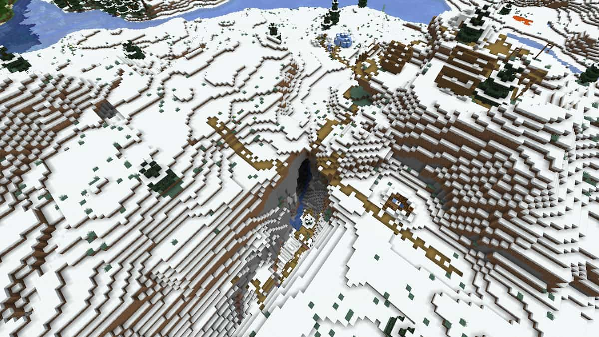 Un village enneigé avec la moitié de ses maisons dans un ravin de Minecraft